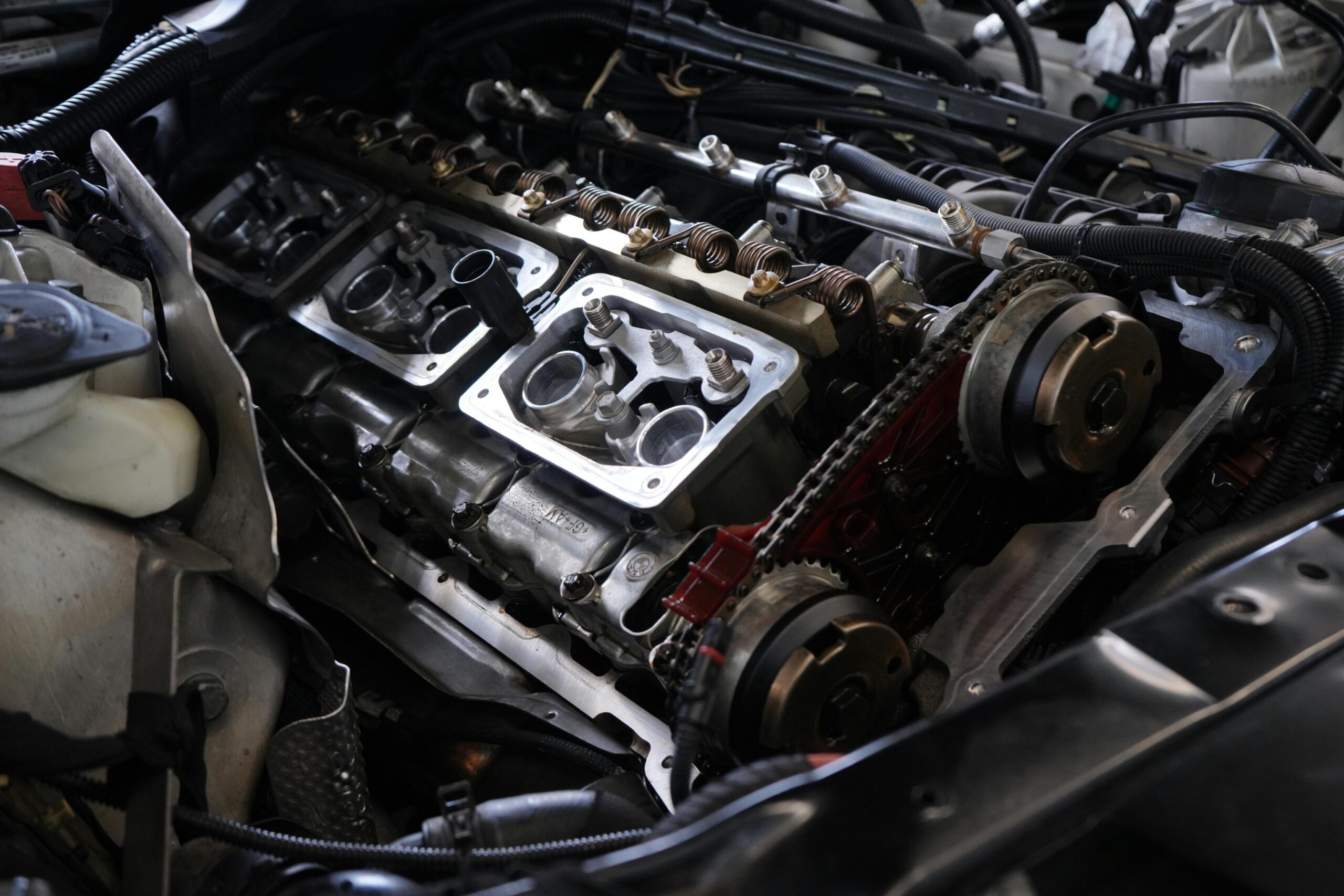 Detailed view of car engine undergoing repair, showcasing intricate mechanical parts.